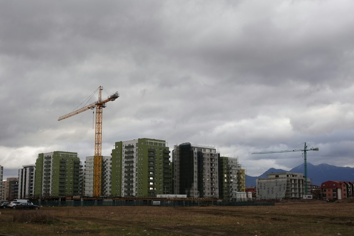 New residential blocks under construction with a tower crane, mountains on the horizon