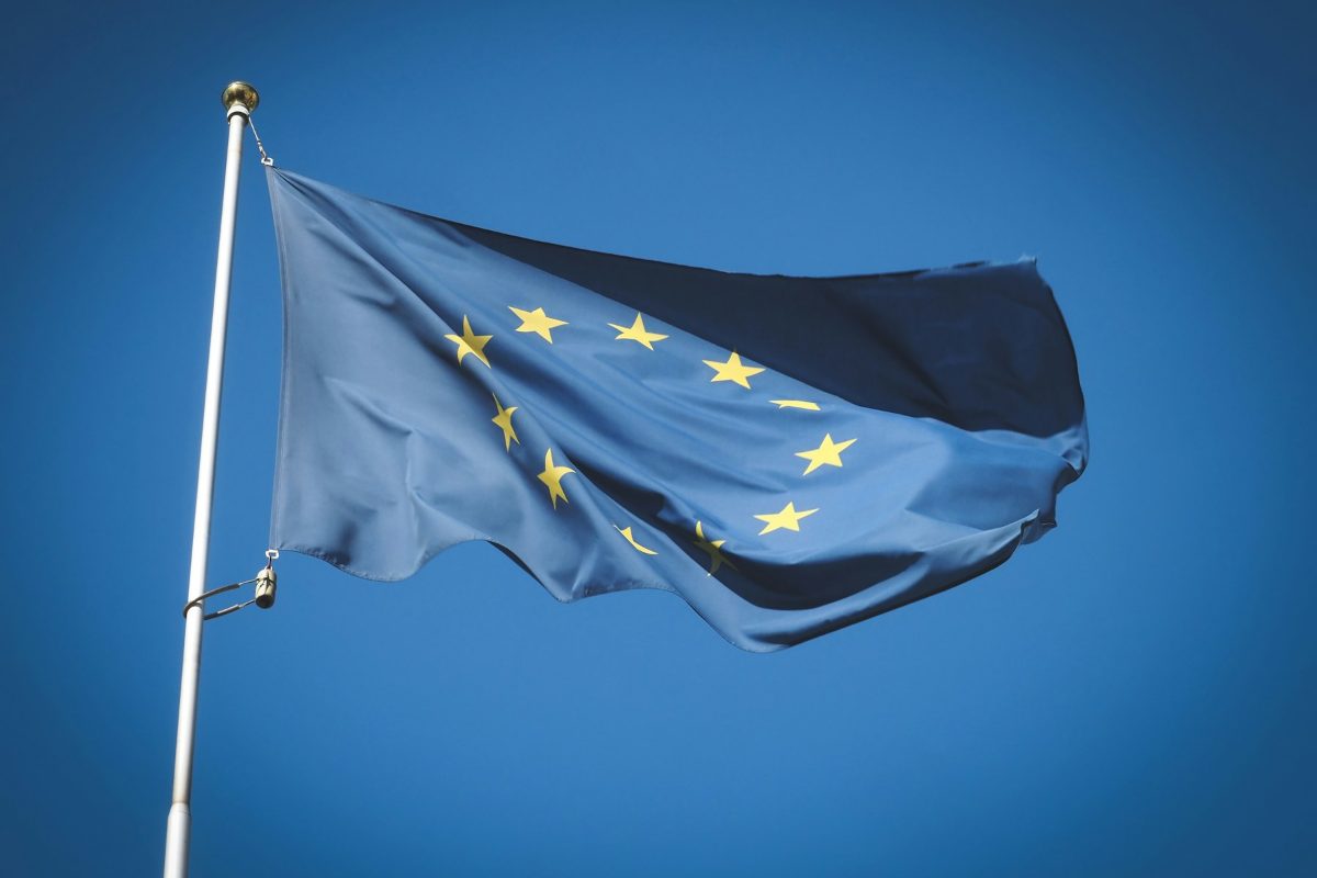 The flag of the European Union flying against a deep blue sky