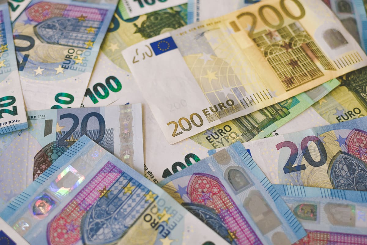 Euro banknotes of various denominations spread across a table