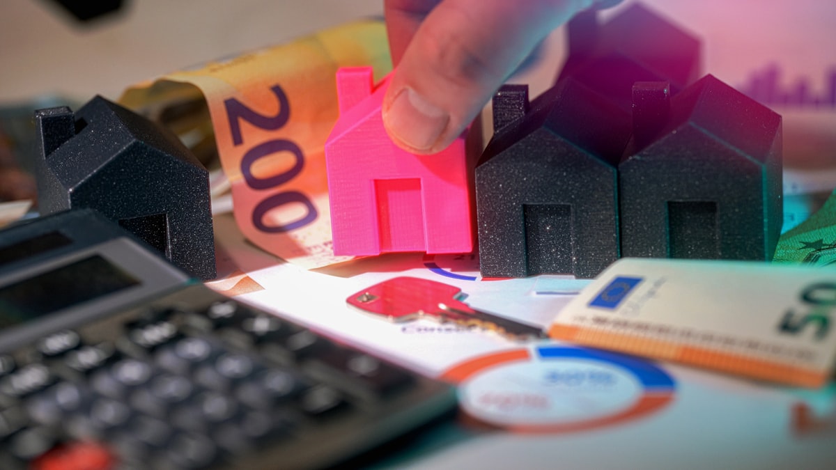 Euro banknotes beside miniature model houses