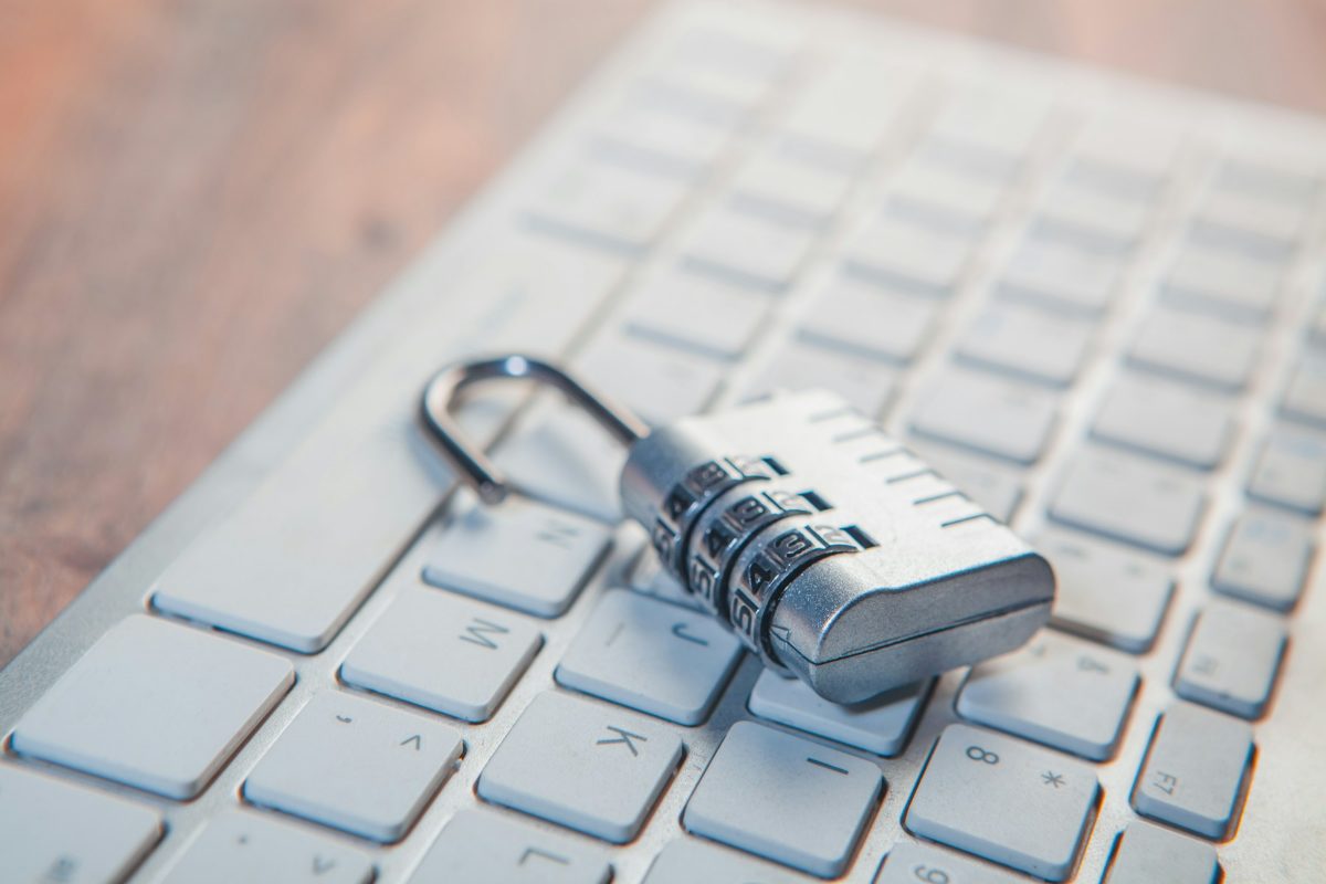 A combination padlock lying on a white computer keyboard