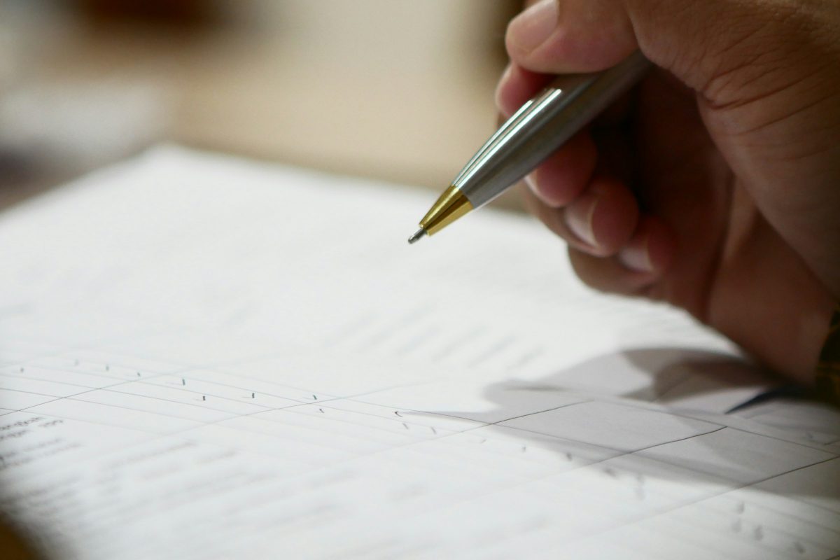 A hand holding a pen over a document
