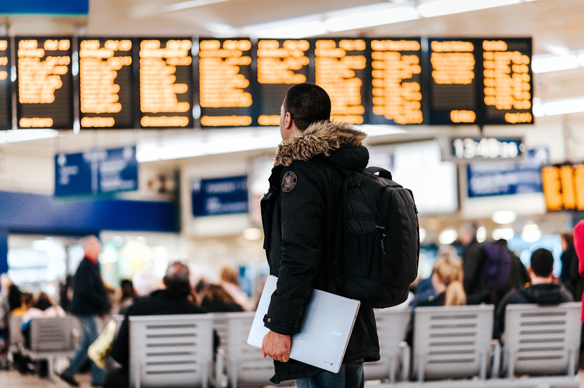 Reisender beim Blick auf eine Abflugtafel am Flughafen