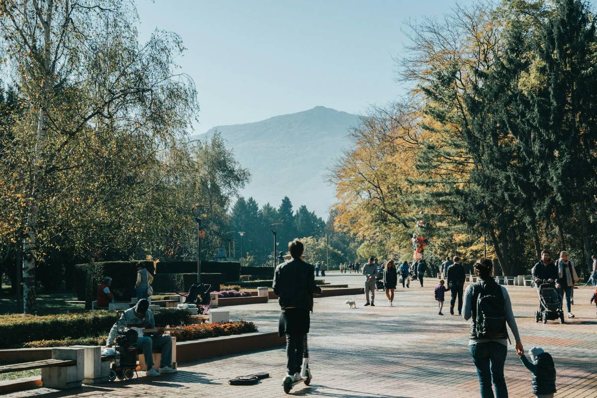 People walking through a park in Sofia on an autumn day, with Vitosha mountain in the background